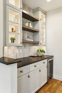 a kitchen with stainless steel appliances white cabinets and a potted plant