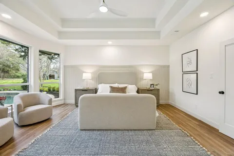 a bedroom with a large bed and wooden floor