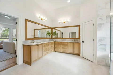 a spacious bathroom with a tub sink shower and mirror