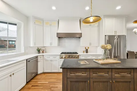 a kitchen with a sink a stove and cabinets