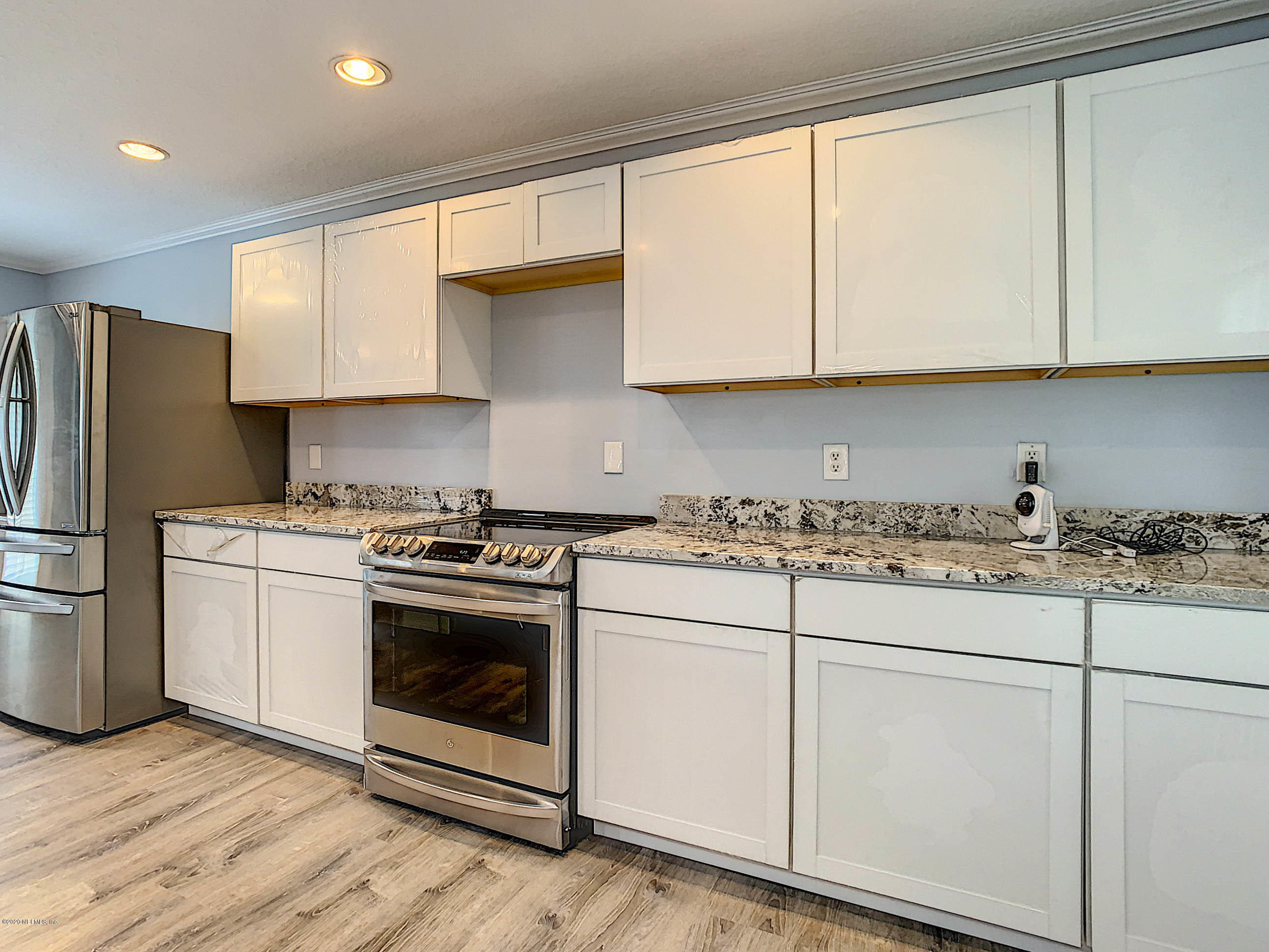 1609 First Street Neptune Beach, FL 32266 - Photo 7 of 30 a kitchen with granite countertop white cabinets and white appliances