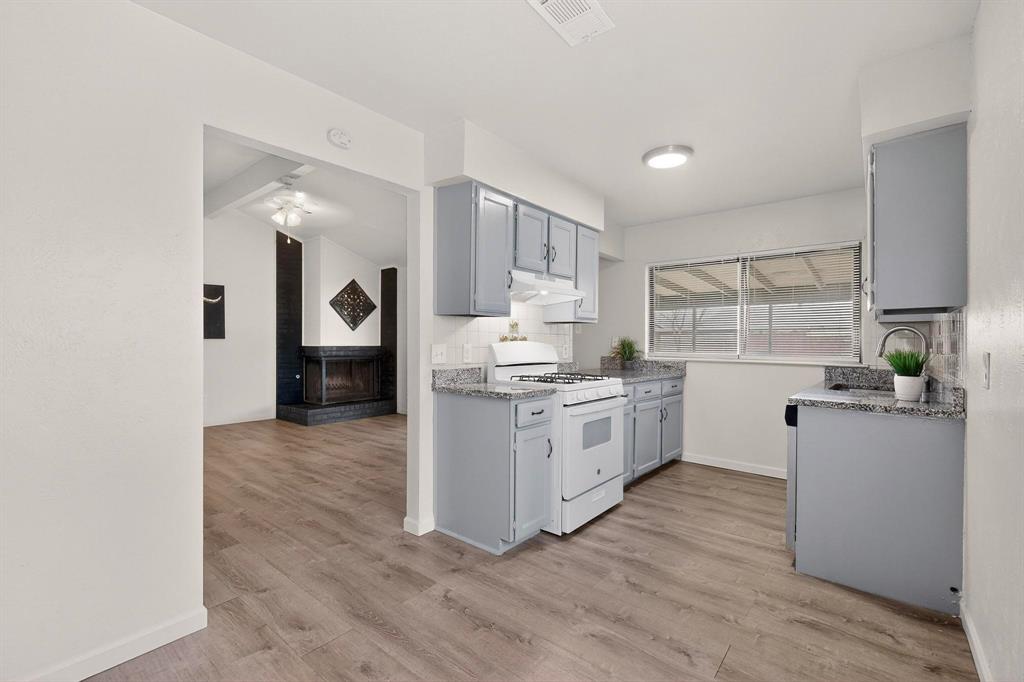 1538 Oakbrook Street Lancaster, TX 75134 - Photo 13 of 34 a kitchen with granite countertop white cabinets and white appliances