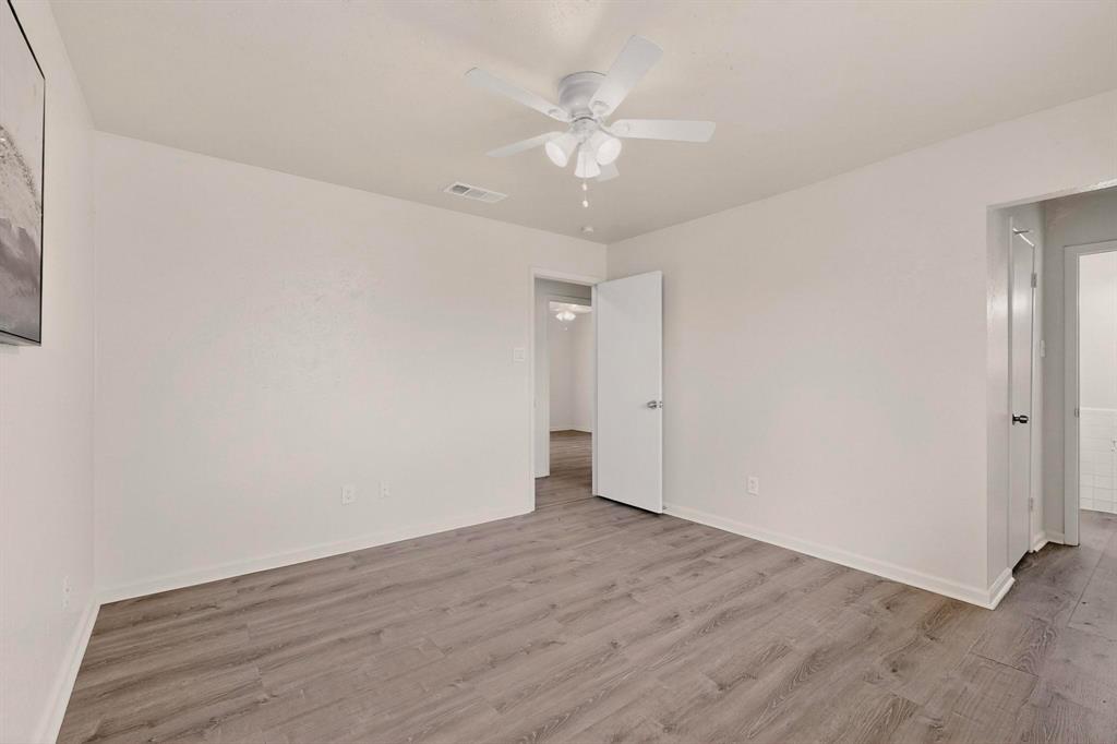 1538 Oakbrook Street Lancaster, TX 75134 - Photo 20 of 34 an empty room with wooden floor and fan