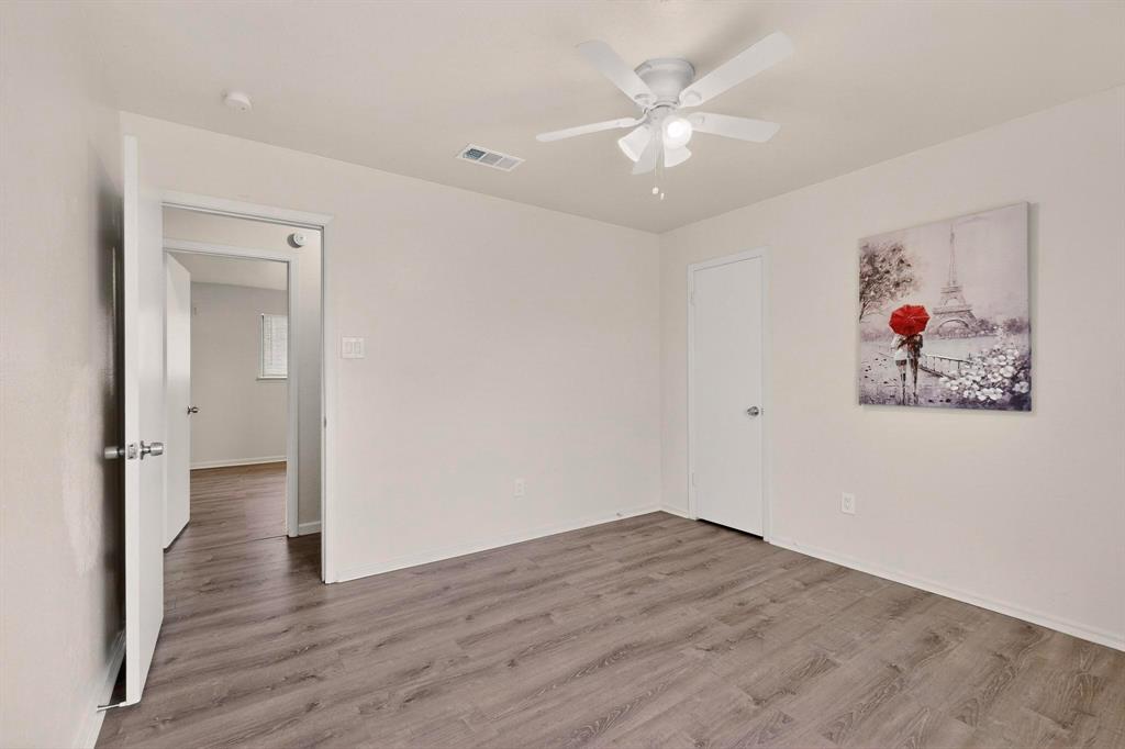 1538 Oakbrook Street Lancaster, TX 75134 - Photo 23 of 34 an empty room with wooden floor and ceiling fan