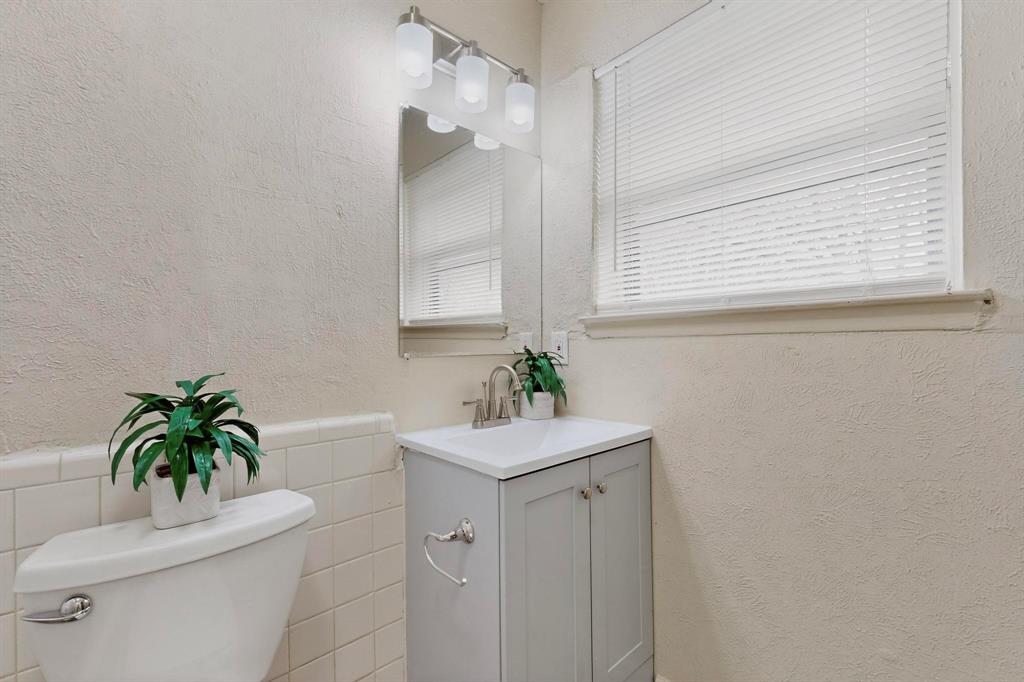 1538 Oakbrook Street Lancaster, TX 75134 - Photo 27 of 34 a bathroom with a sink a toilet and a mirror
