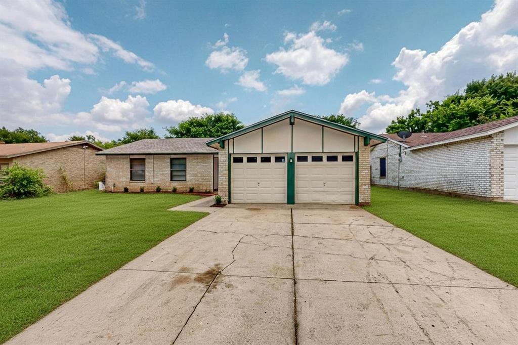 1538 Oakbrook Street Lancaster, TX 75134 - Photo 32 of 34 a front view of a house with a yard and garage