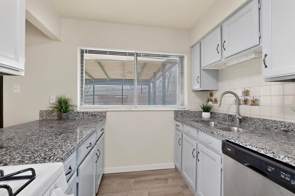 1538 Oakbrook Street Lancaster, TX 75134 - Photo 7 of 34 a kitchen with granite countertop a sink window and cabinets