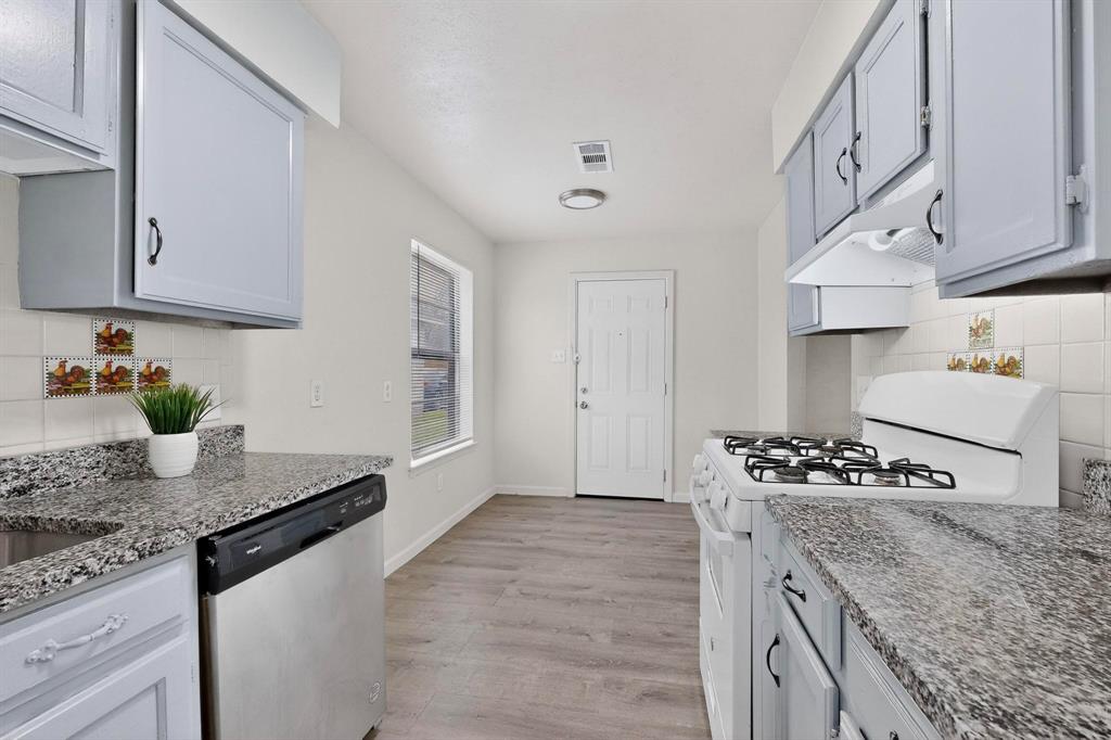 1538 Oakbrook Street Lancaster, TX 75134 - Photo 10 of 34 a kitchen with granite countertop a sink stove and cabinets