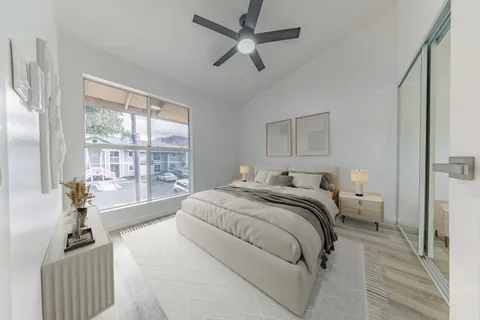 a spacious bedroom with a bed and a large window