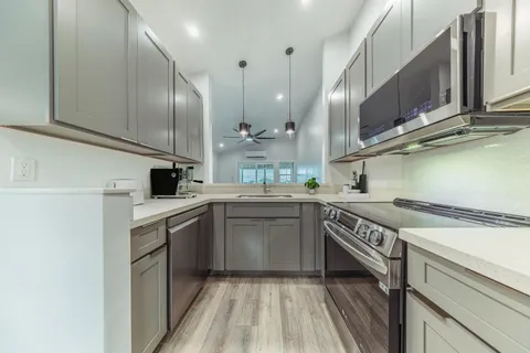 a kitchen with stainless steel appliances granite countertop a sink a stove and a refrigerator