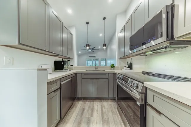 a kitchen with stainless steel appliances granite countertop a sink a stove and a refrigerator