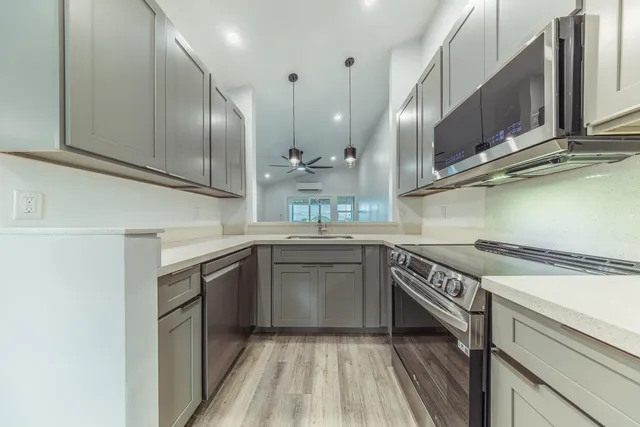 a kitchen with stainless steel appliances granite countertop a sink a stove and a refrigerator