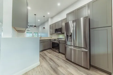a kitchen with stainless steel appliances a refrigerator and a stove top oven