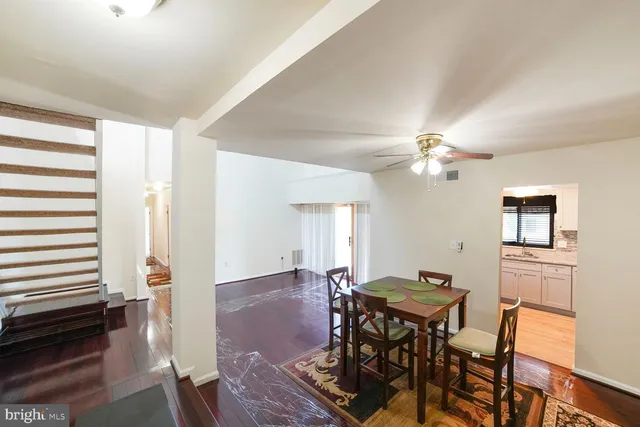a view of an empty room with kitchen and a window