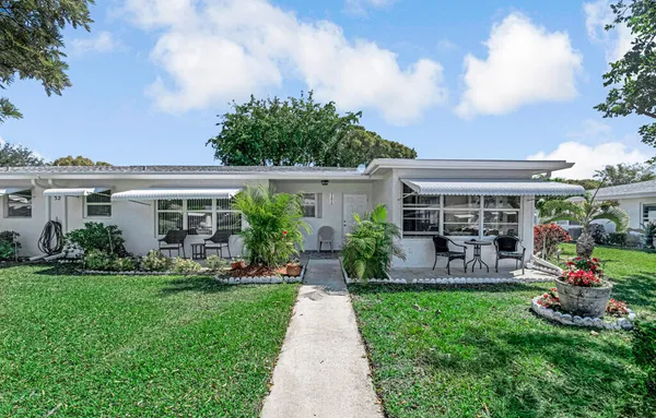 a front view of house with yard and outdoor seating