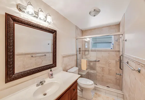a bathroom with a sink a toilet and shower