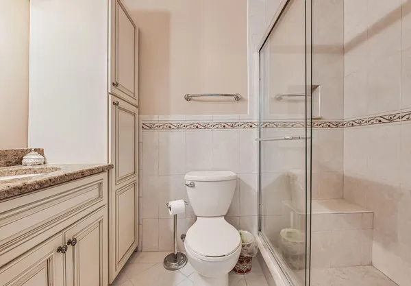 a bathroom with a granite countertop toilet sink and mirror