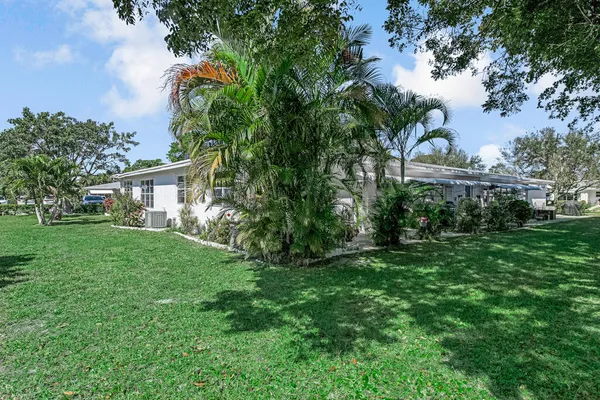 a front view of a house with a yard and potted plants