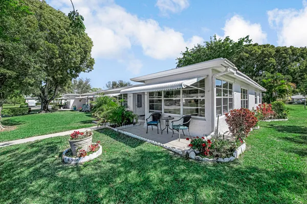 a front view of house with a garden and patio