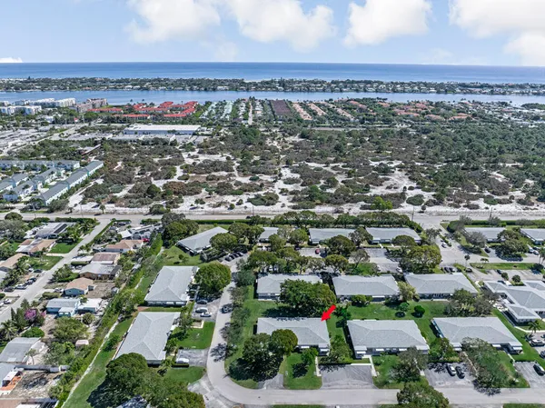 an aerial view of residential houses with outdoor space and parking