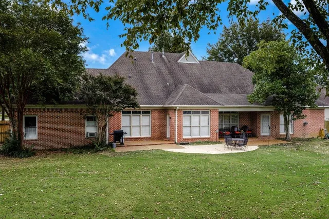 a backyard of a house with table and chairs