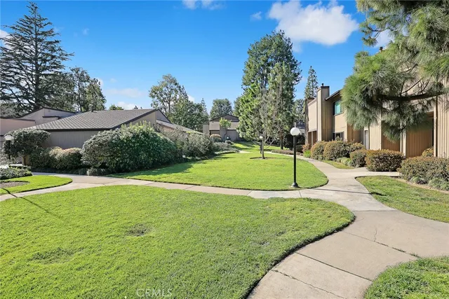 a view of a house with a yard and basketball court