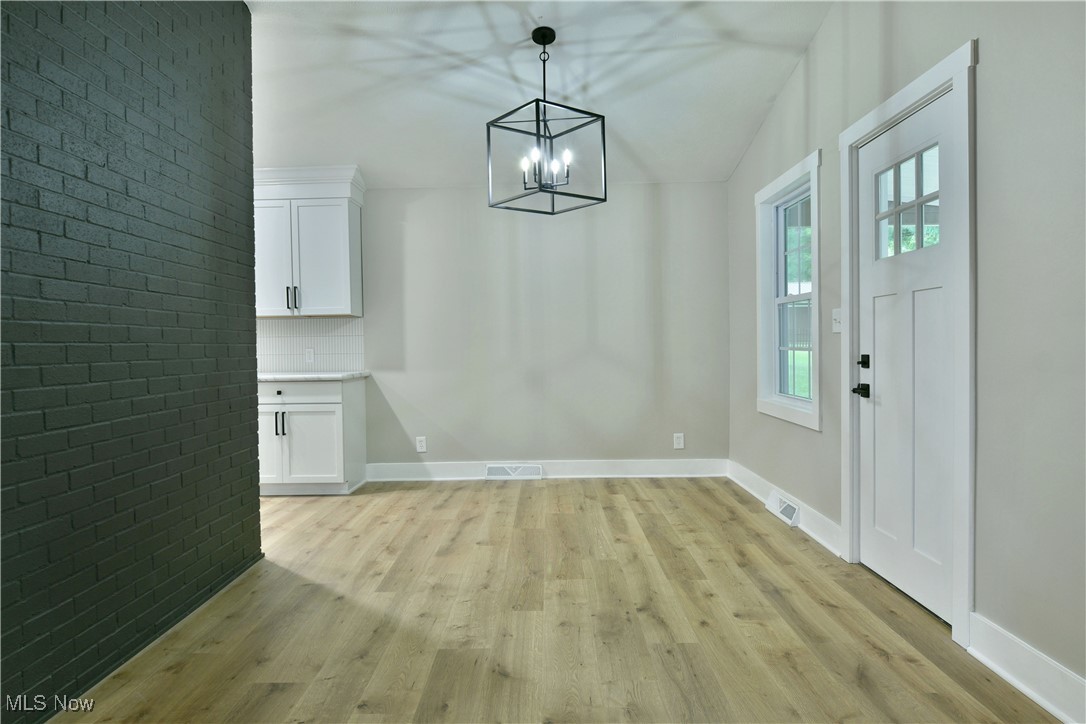 7655 Connelly Road Masury, OH 44438 - Photo 17 of 46 Unfurnished dining area featuring light wood finished floors and a chandelier