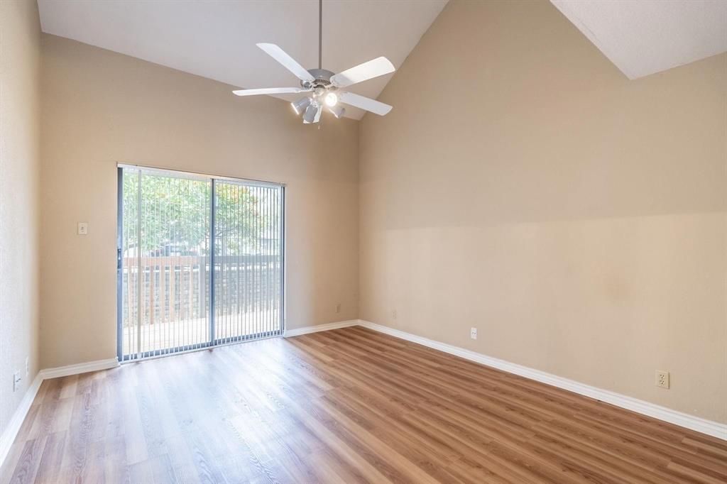 1518 Signal Ridge Place Rockwall, TX 75032 - Photo 7 of 13 Interior room featuring vaulted ceilings, wood-finish flooring, a ceiling fan with integrated lighting, and sliding glass doors leading to an exterior balcony