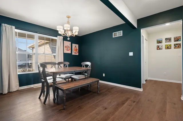 a living room with furniture a dining table and a chandelier