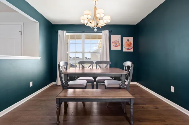 a view of a dining room with furniture a chandelier and wooden floor