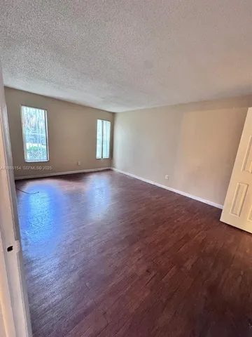 an empty room with wooden floor and window
