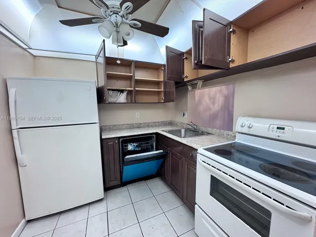a kitchen with stainless steel appliances granite countertop a sink and a refrigerator