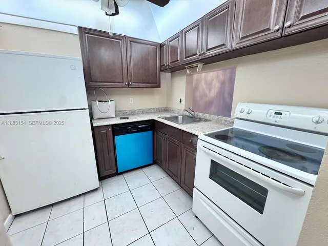 a kitchen with a stove sink and cabinets
