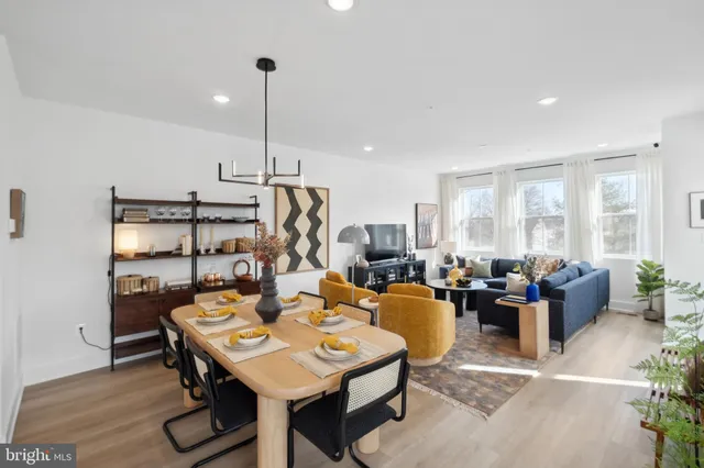 a view of a dining room and livingroom with furniture wooden floor a rug a chandelier