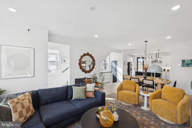 a living room with furniture kitchen view and a flat screen tv