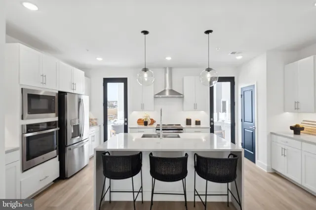a kitchen with stainless steel appliances a sink a stove a refrigerator and cabinets