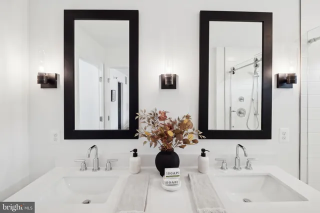 a bathroom with a double vanity sink a mirror and shower