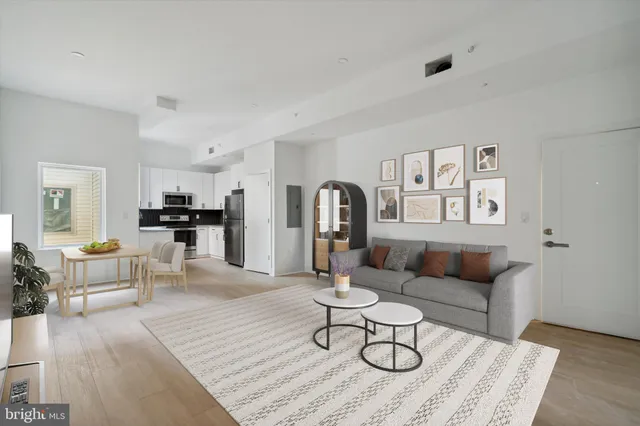 a living room with furniture and kitchen view