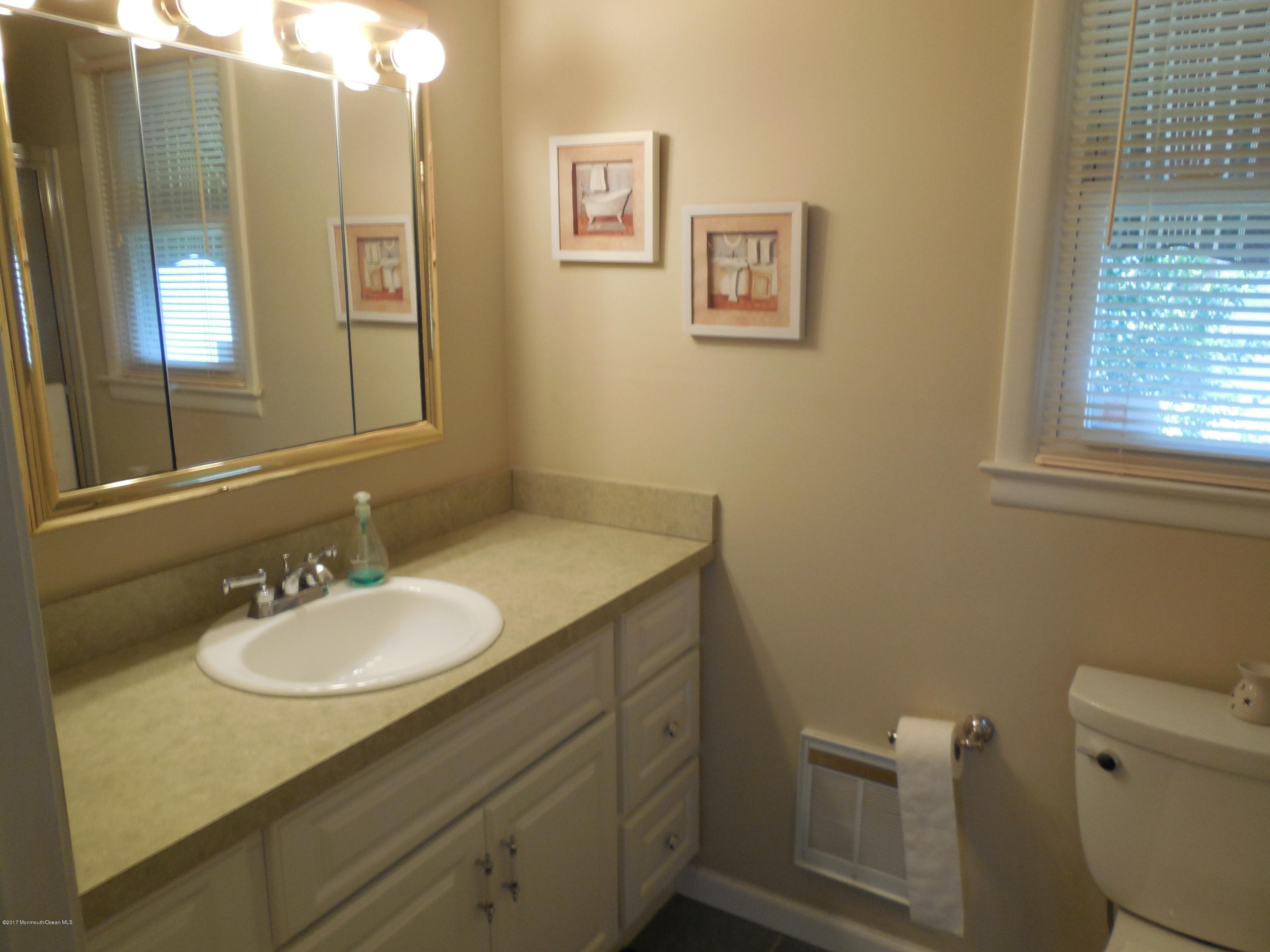 26 Phillips Road Brick, NJ 08724 - Photo 10 of 16 a bathroom with a granite countertop sink toilet and a mirror