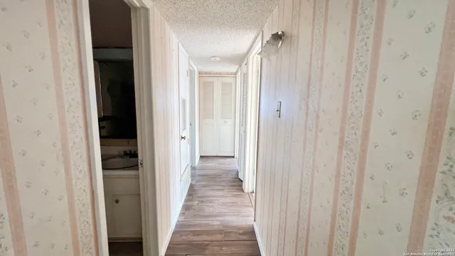 a view of a hallway with wooden floor