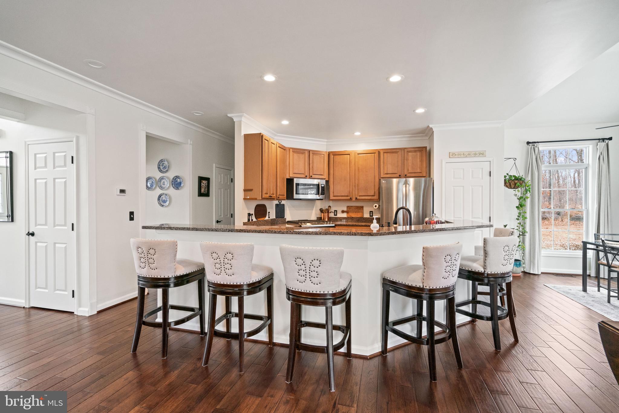 10448 Wheatley School Road Marshall, VA 20115 - Photo 9 of 43 a kitchen with stainless steel appliances granite countertop a dining table chairs refrigerator and sink