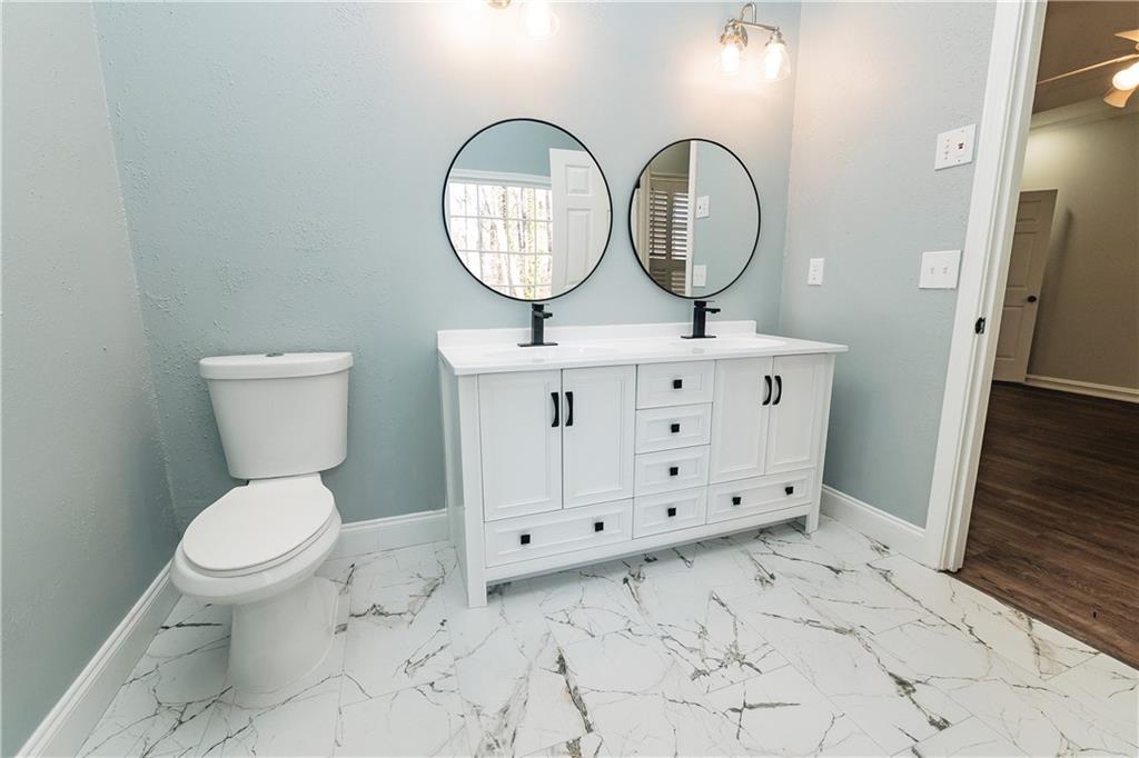 525 Rams Way Tucker, GA 30084 - Photo 24 of 41 a bathroom with a toilet a sink and a mirror