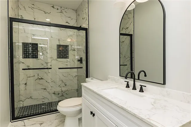 a bathroom with a sink a toilet and shower