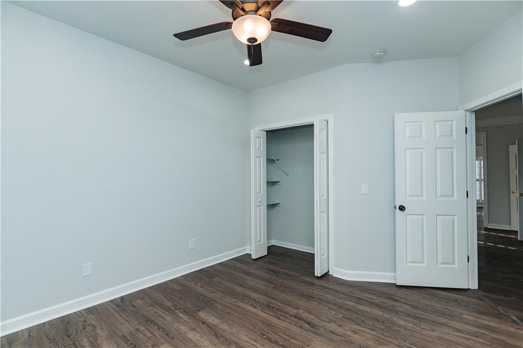 525 Rams Way Tucker, GA 30084 - Photo 34 of 41 an empty room with wooden floor chandelier fan and closet area