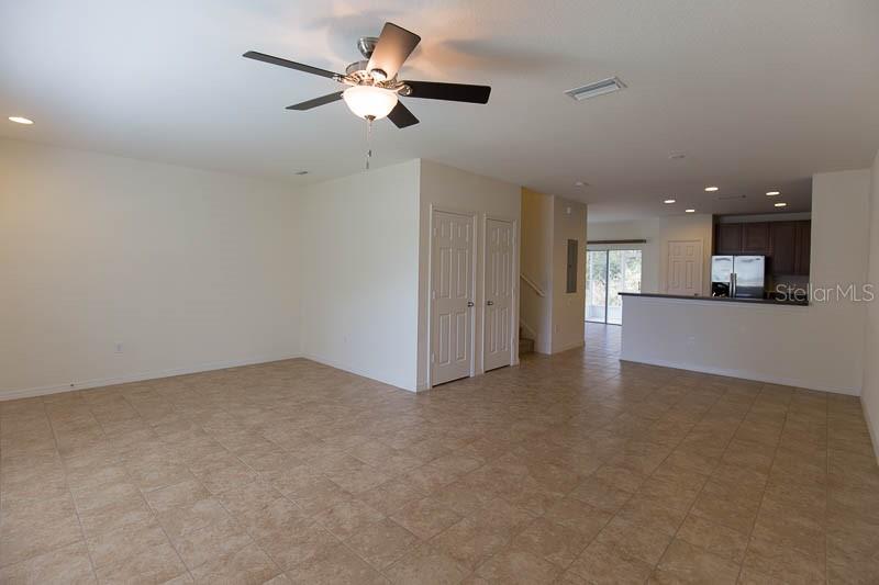 15810 Fishhawk View Drive Lithia, FL 33547 - Photo 7 of 34 an empty room with a kitchen and a ceiling fan