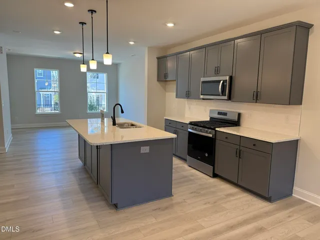 a kitchen with kitchen island granite countertop a sink counter top space stainless steel appliances and cabinets