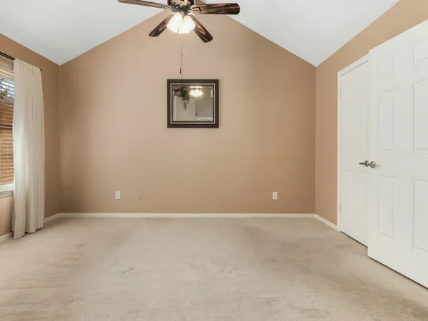 an empty room with windows and fan