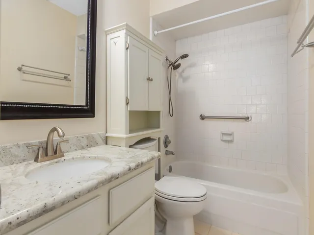 a bathroom with a granite countertop sink a toilet and shower