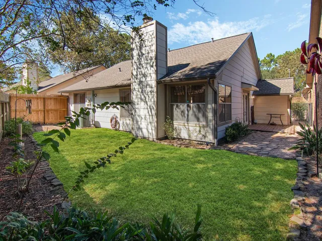 a view of a house with brick walls and a yard with plants