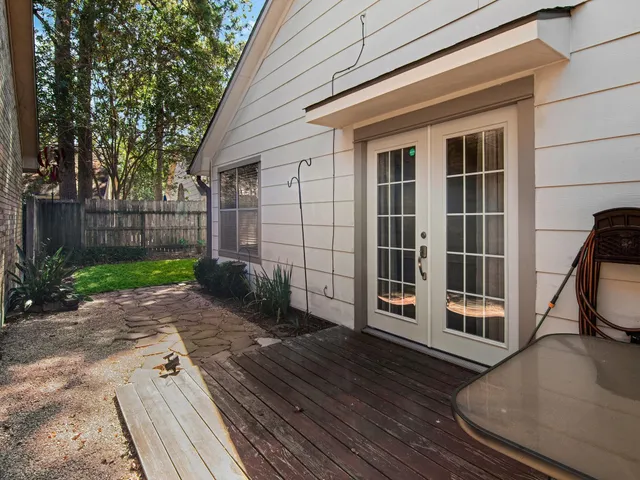 a view of a house with a large window and wooden fence